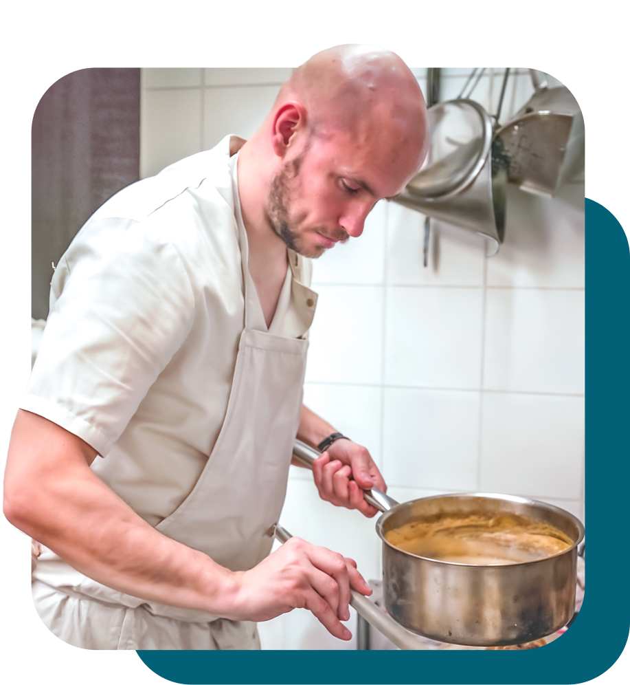 Koch bereitet eine Speise in der Küche vor.